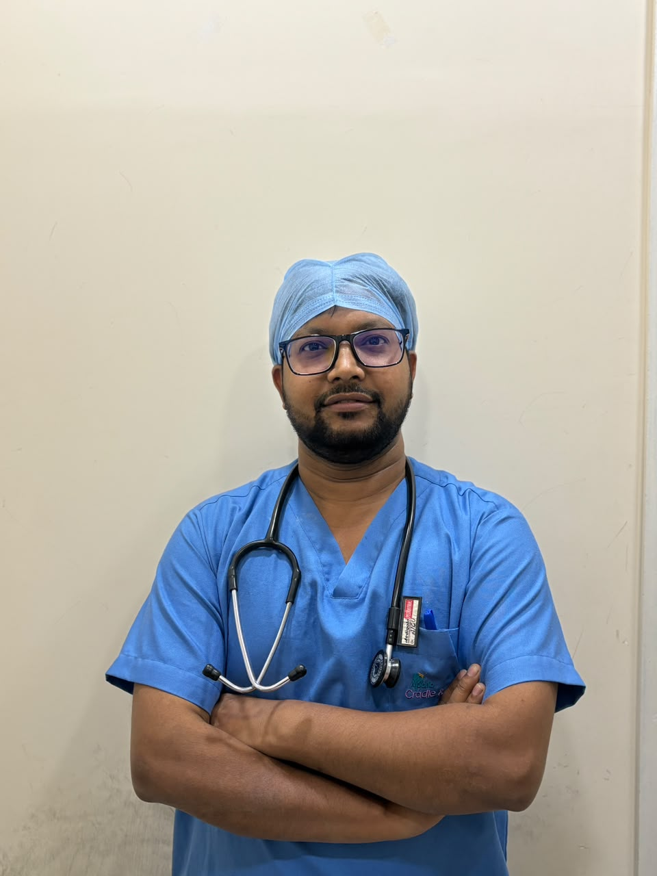 Dr. Vishwanath in surgical scrubs and cap at Wellnest Child Care and Vaccination Centre