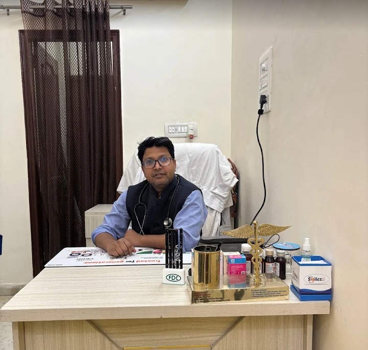 Dr. Vishwanath seated at his consultation desk at Wellnest Child Care and Vaccination Centre